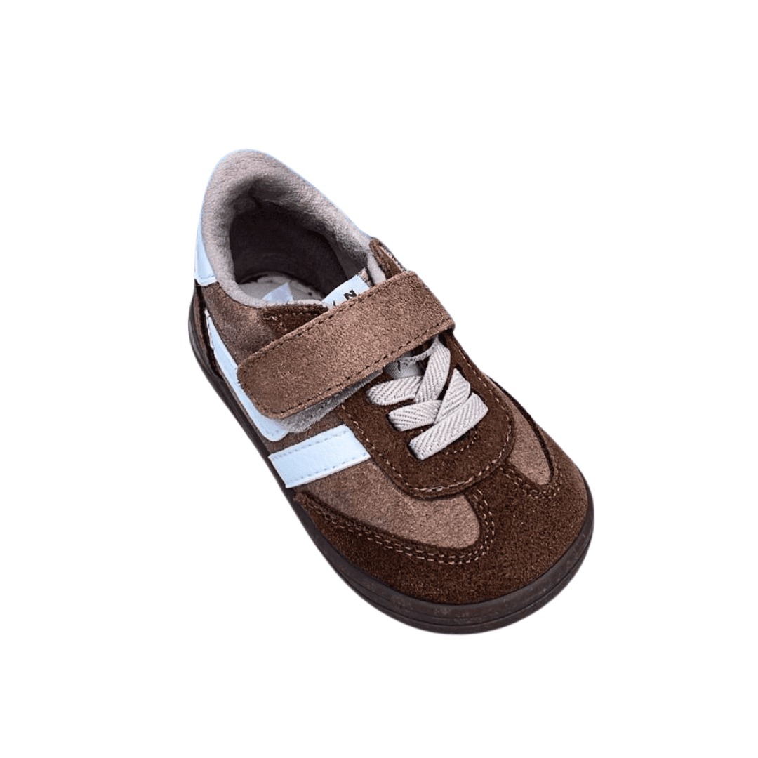 La zapatilla respetuosa Zapyflex marrón y blanca de ante combina estilo y confort para acompañar el crecimiento natural de los pies de tu peque.